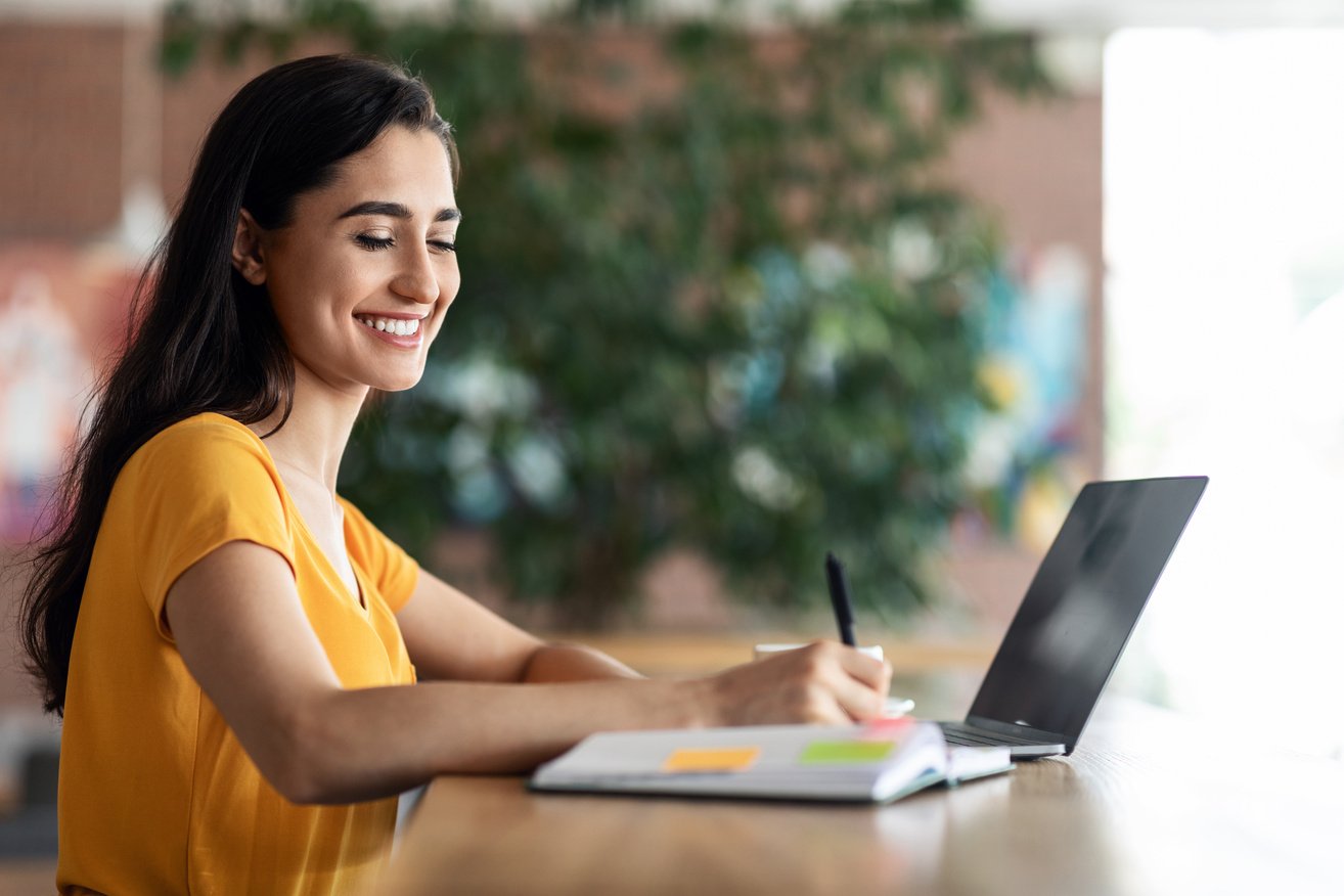 Female student looking for part-time job, using laptop at cafe